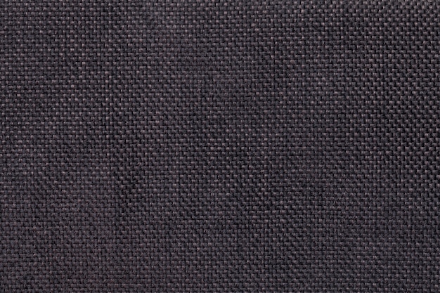 Dark brown background of dense woven bagging fabric, closeup