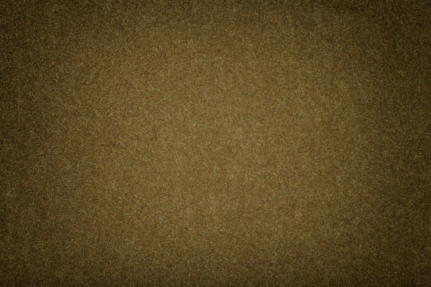 Dark brown matt suede fabric closeup. Velvet texture of felt.