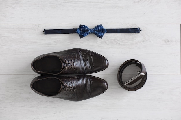 Dark brown men's shoes and strap on a white background