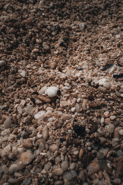 Photo dark brown natural texture of tiny beige beach pebbles vertical background