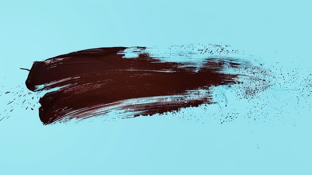 Photo dark brown paintbrush stroke with scattered paint splatters on a blue background