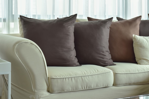 Photo dark brown pillows setting on beige color sofa