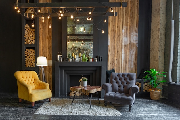 Dark brutal interior of sitting room decorated with wooden logs. yellow and grey soft armchairs, huge arc window and fireplace