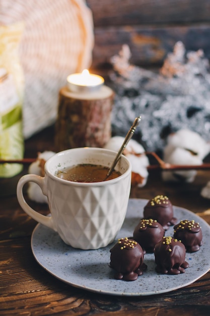 写真 白いカップのお茶とダークウッドの背景に手作りプレートにダークチョコレート手作りキャンディーボール