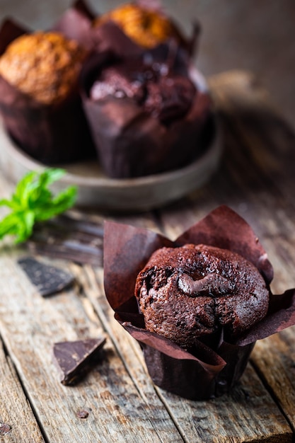 Dark chocolate muffin with mint on a wooden table homemade baking