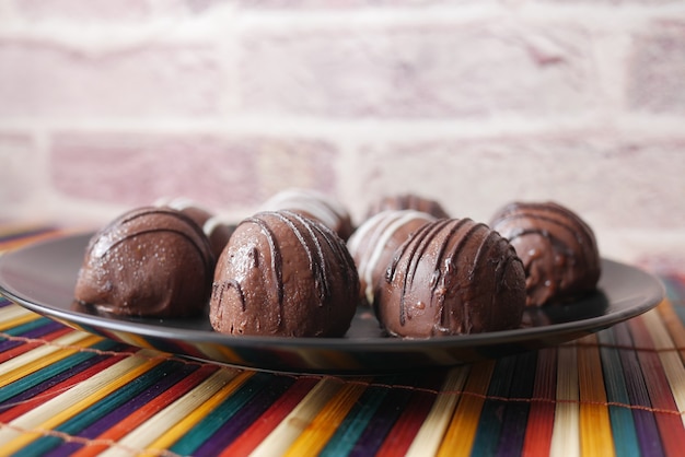 Dark chocolate on a plate on pink background