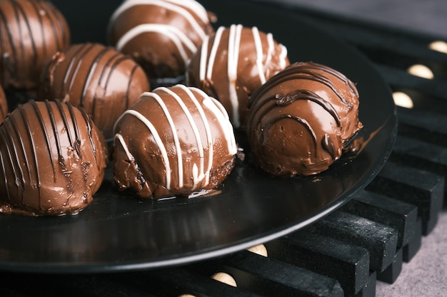 Dark chocolate on a plate on pink background