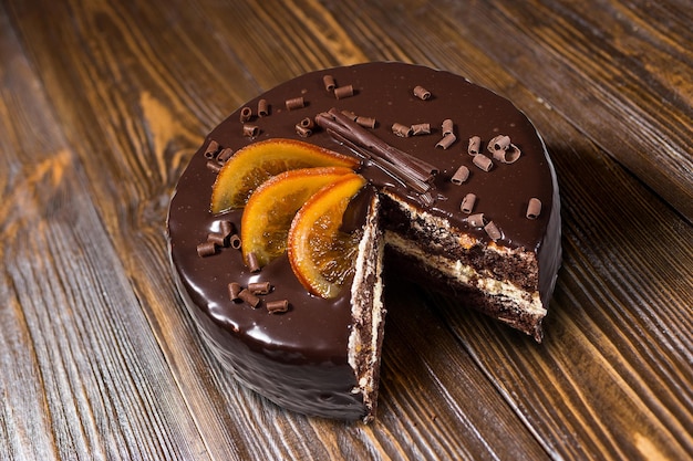 Dark chocolate vegan cake with Candied Oranges on wooden background