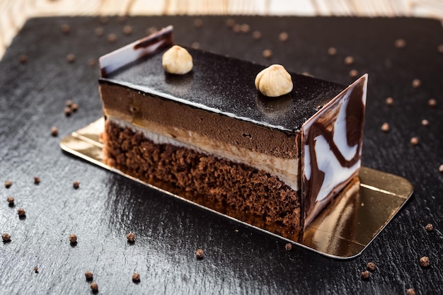 Torta vegana al cioccolato fondente con caramelle e noci su fondo di legno