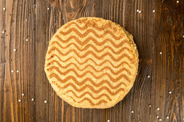 Torta vegana al cioccolato fondente con caramelle e noci su fondo di legno