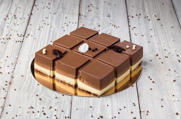 Dark chocolate vegan cake with candies on wooden\
background