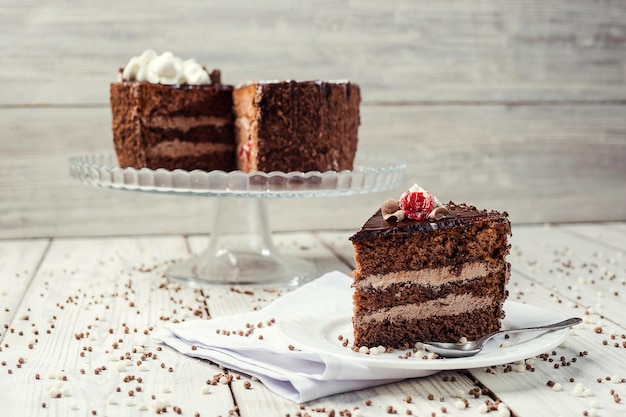 木製の背景にチェリーとダークチョコレートビーガンケーキ