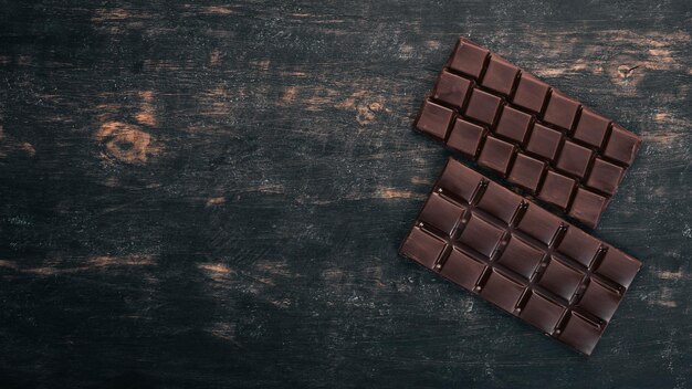 Foto cioccolato fondente su un tavolo di legno vista dall'alto copia spazio per il testo