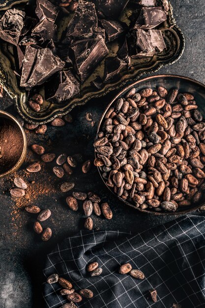 Dark chokolate cocoa beans and powder on concrete table