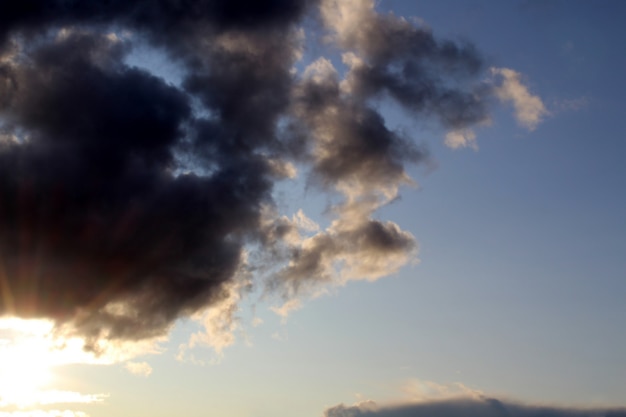 Dark clouds before the rain have covered the entire sky small sun rays