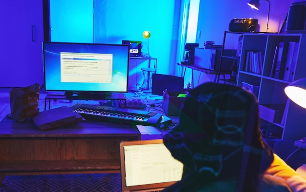 Dark coding and woman with a computer for hacking data thief and stealing database information Criminal scam and hacker in a room at night for software password server and network fraud online