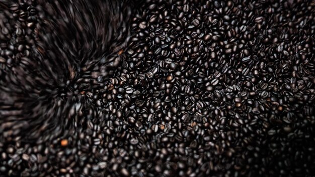 dark coffee beans and roasted spinning cover professional machine close up