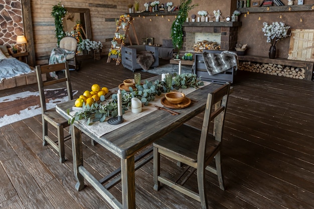 Foto interni scuri e accoglienti di una grande casa in legno di campagna, mobili in legno e pellicce di animali. enorme finestra panoramica e soffitto molto alto.