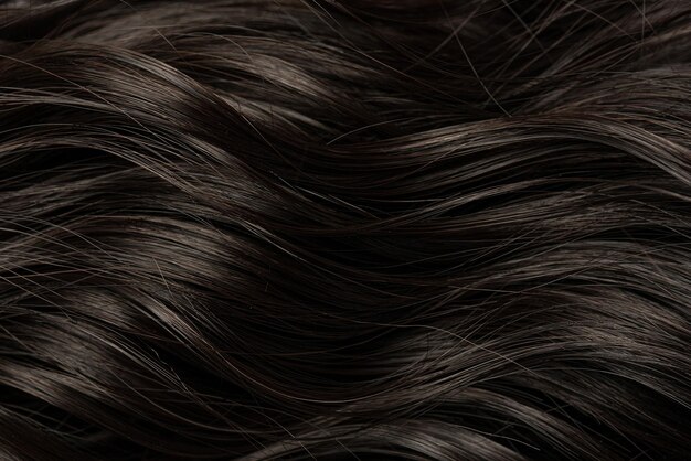 Photo dark curly long hair in closeup a wave of hair as a background