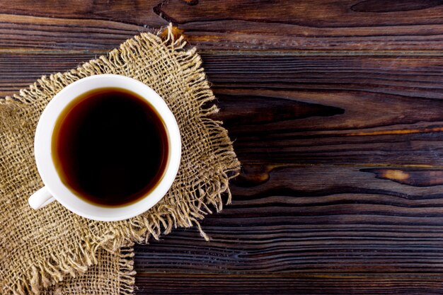 Dark espresso in a cup on burlap surface