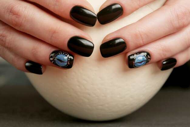 Dark fantasy nail art on manicured hands close-up