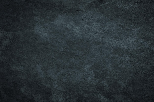 Dark gloomy black grunge surface background with scratched stained texture