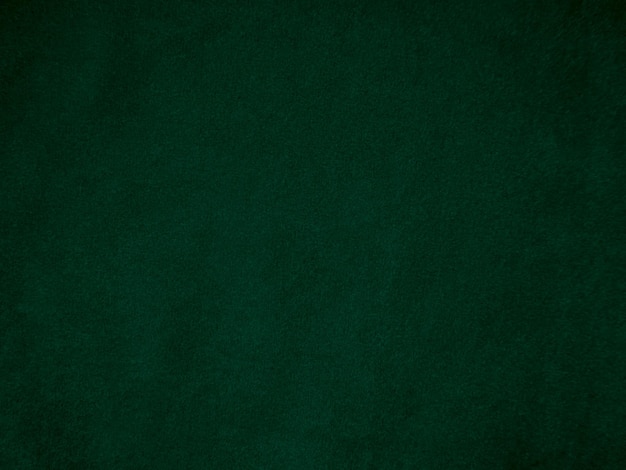Текстура темно-зеленой старой бархатной ткани, используемая в качестве фона. Пустой зеленый фон ткани из мягкого и гладкого текстильного материала. Есть место для текста.