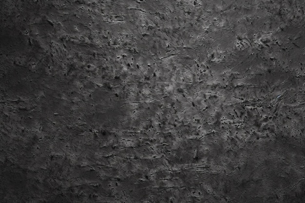 A dark grey wall with a rough textured surface.