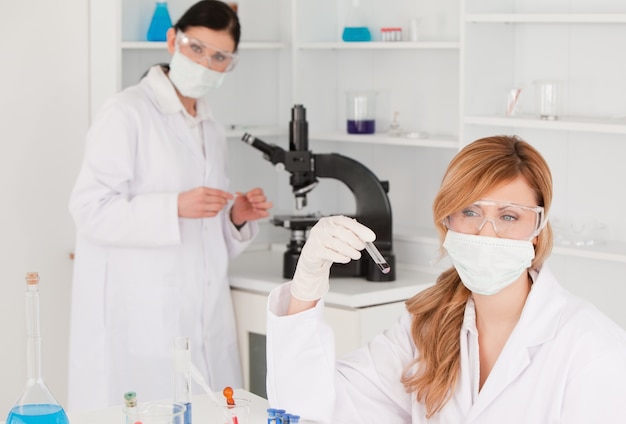 Dark-haired and blond-haired scientists carrying out an experiment