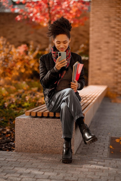 Dark-haired cute young girl sitting with a phone in hands