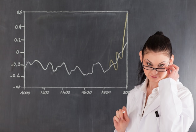 Dark-haired scientist standing near the blackboard 