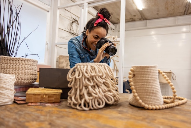 Photo dark-haired woman making photos of handmade bags