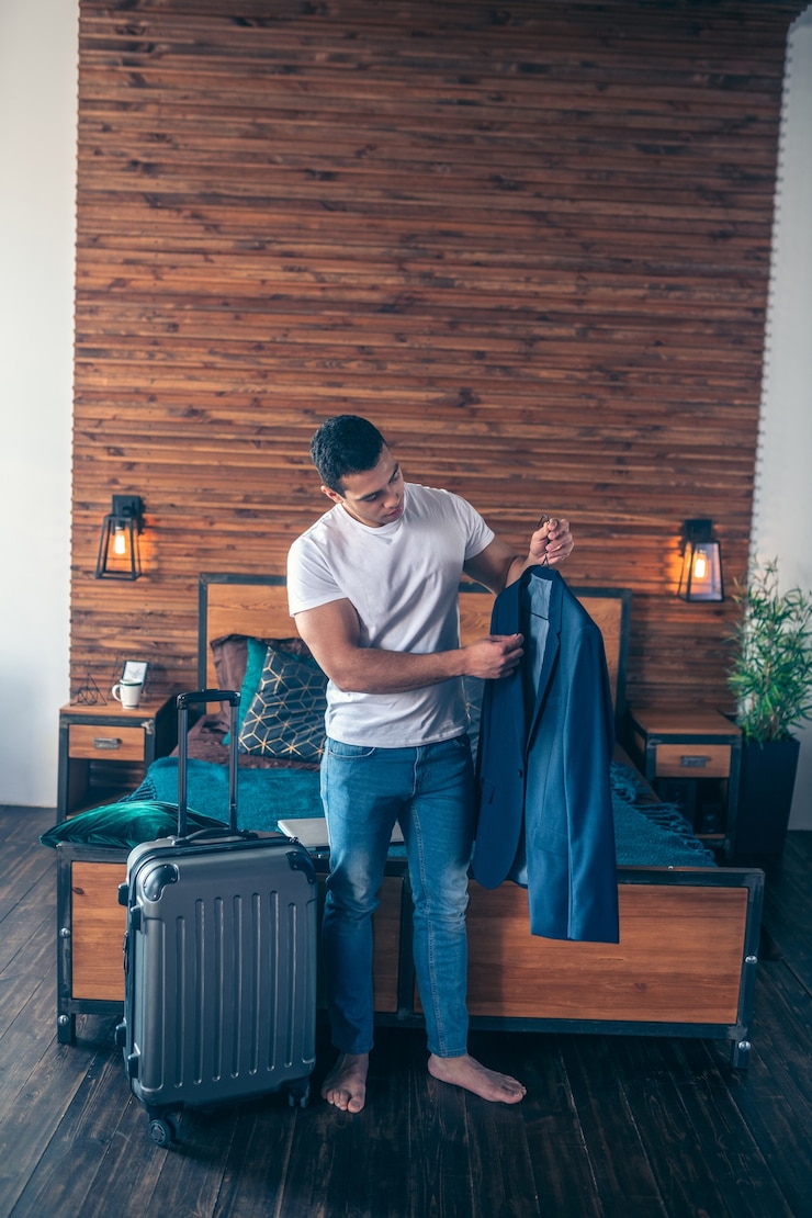Photo dark-haired young man in white tshirt getting ready for working trip