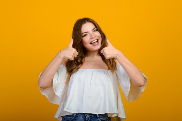 Dark-haired young woman with a smile and big suprised eyes posing.