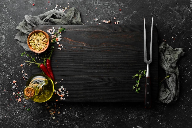 Dark kitchen wooden board with cutlery on a black stone background. Restaurant menu. Banner. Top view.