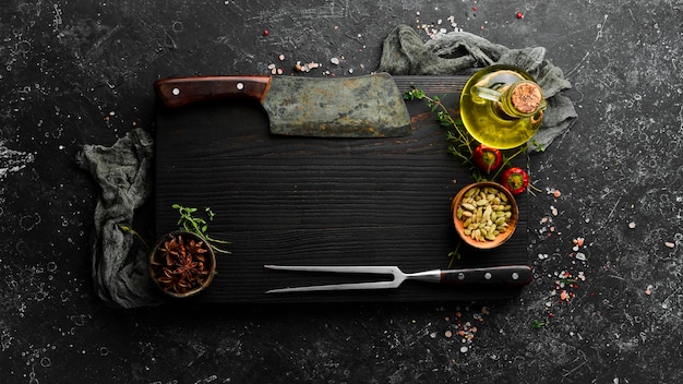 Dark kitchen wooden board with cutlery on a black stone background Restaurant menu Banner Top view