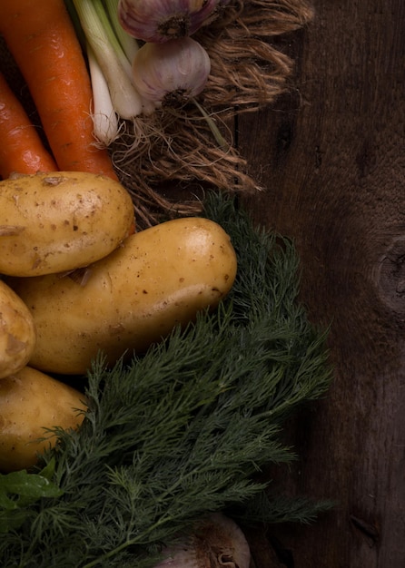 Темный угрюмый натюрморт из свежих овощей на деревянном столе Здоровая органическая местная еда