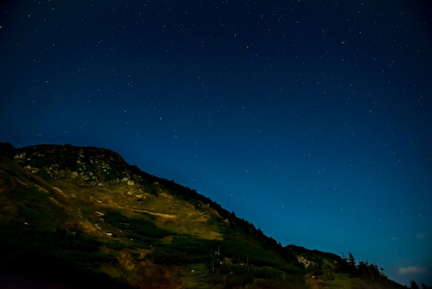 Dark night with stars at sky over mountain