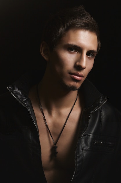 Dark portrait of stylish muscular handsome men with perfect strong body in black leather jacket, isolated at black background