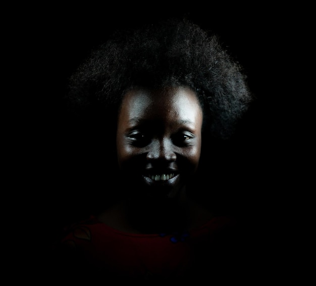 Dark portrait of young black woman in studio