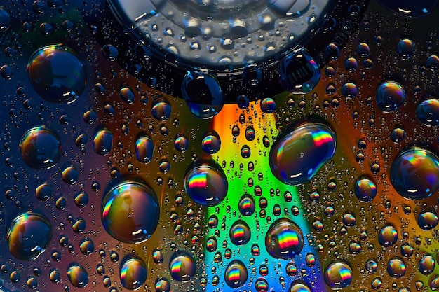 Dark rainbow burst inside fizzy bubbles floating across colorful metallic surface