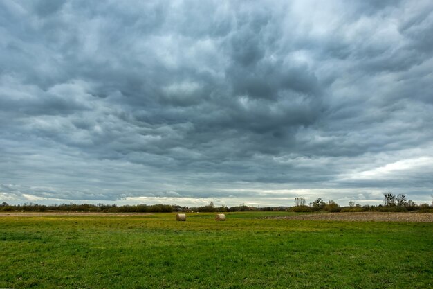 Photo dark rainy clouds over the meadow