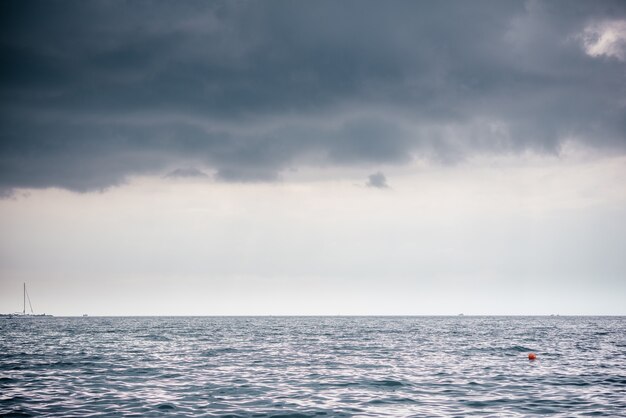 Dark rainy clouds over the sea surface landscape