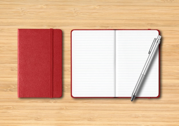 Dark red closed and open lined notebooks with a pen