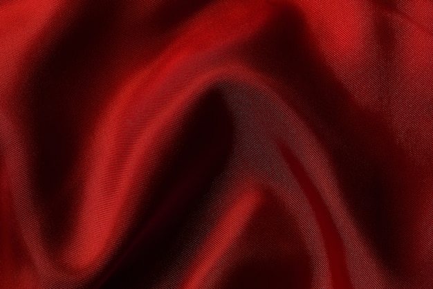 Dark red fabric texture background, crumpled silk or linen.