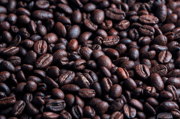 Dark roasted coffee beans close up background