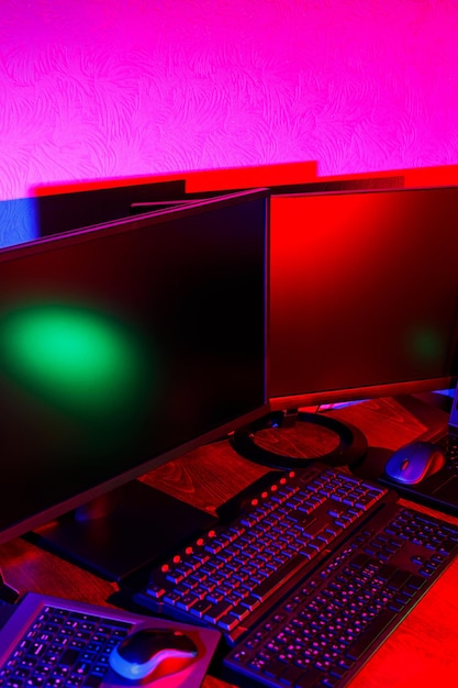 Stanza buia per un giocatore con luci al neon. interni per giochi per computer, sport di gioco e streaming. sfondo astratto al neon all'interno. area di gioco. neon blu e rosa