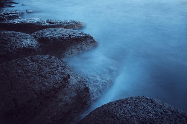 Dark sea landscape. Stones and foggy water