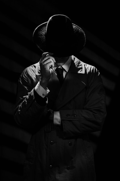 A dark silhouette of a man in a coat and hat in the noir style A dramatic portrait in the style of detective films of the 1950s and 60s The silhouette of a spy