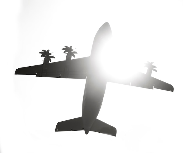 Фото Темный силуэт самолета на фоне неба с солнечным светом, вид снизу.